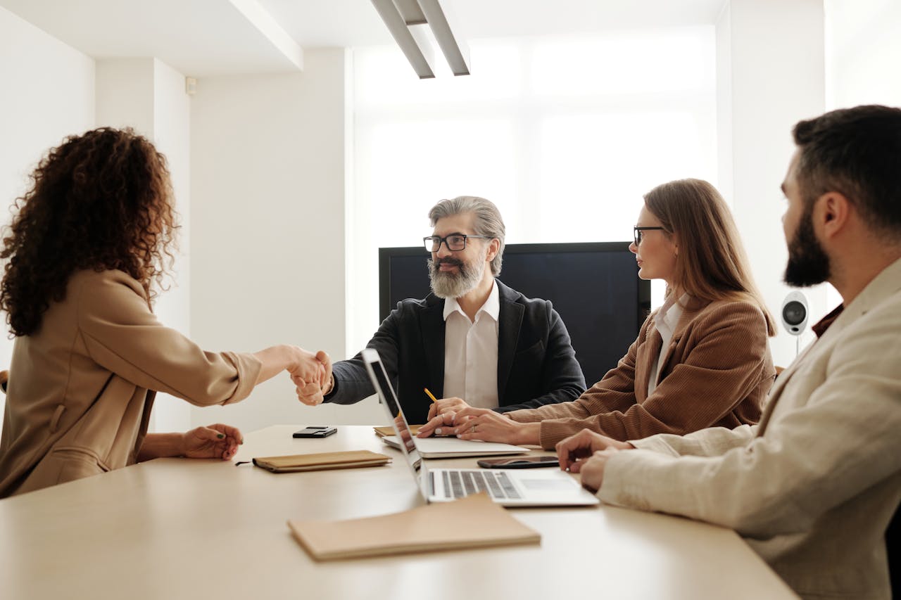 hero-homepage Colleagues in an office celebrating a successful negotiation with a handshake.