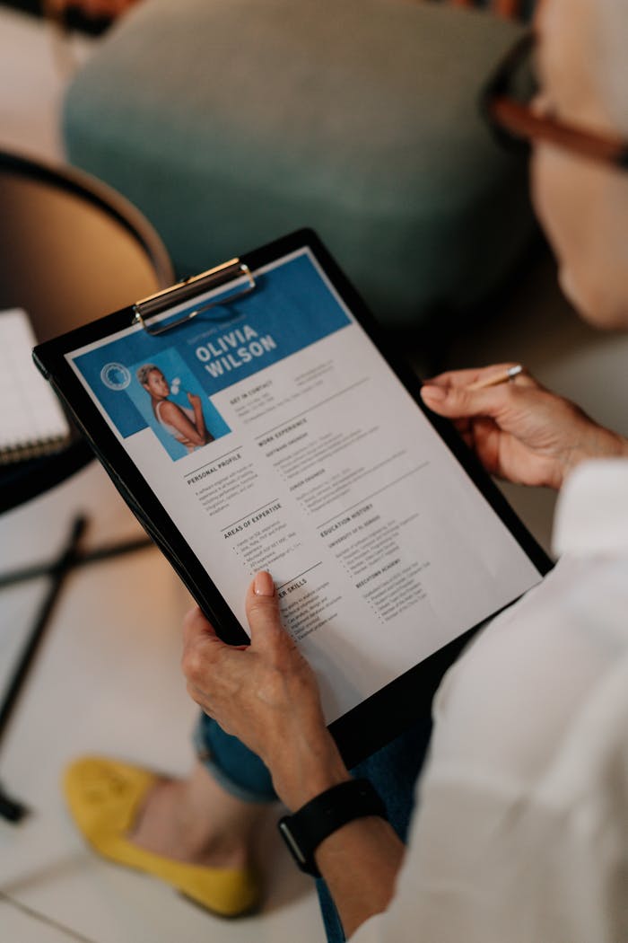 hero-services An HR professional reviews a resume on a clipboard during an office meeting.